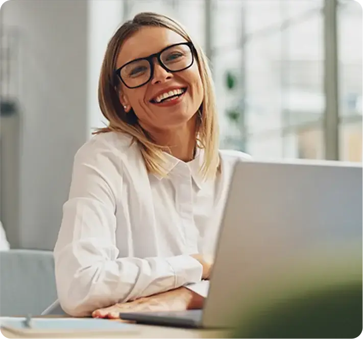 Executiva sorrindo com seu computador em sua frente